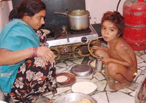 Amandeep drinks petrol at his residence, while his mother cooks food in Moga.