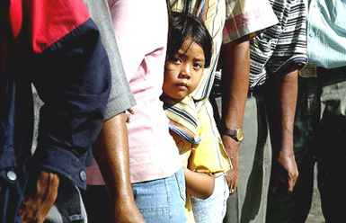 A child stands in a queue for potable water in Banda Aceh