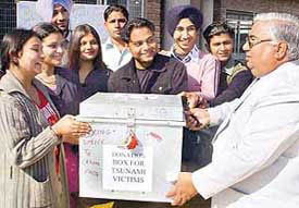 Students of Sanatan Dharam College, Sector-32, hand over a box containing relief for tsunami victims to college Principal in Chandigarh on Wednesday. 