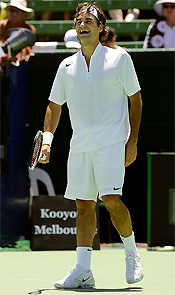 Roger Federer of Switzerland laughs during his match against Gaston Gaudio of Argentina at the Kooyong Classic tennis tournament in Melbourne on Wednesday