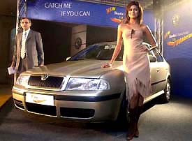 Imran Hassen, Managing Director, Skoda Auto India poses with a model at the launch of Octavia Rider in New Delhi on Thursday