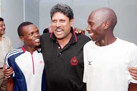 Former cricketer Kapil Dev greets leading Kenyan athletes Joseph Kahugu and John