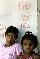 Sri Lanka tsunami survivors, Chempika, 15, and Pavani, 8, await at the entrance of their school at Paraliya village