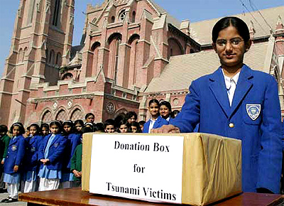 Students donate money for the survivors of the tsunami disaster at the Cathedral School in Lahore on Thursday