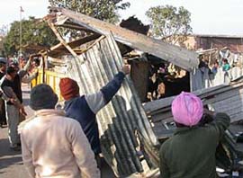 Municipal Council Mohali employees remove kiosks in meat market during an anti-encroachment drive in Mohali on Friday.