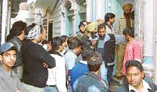 The police and area residents outside the house where a girl and her fiance were shot dead by the girls father in Ludhiana on Friday