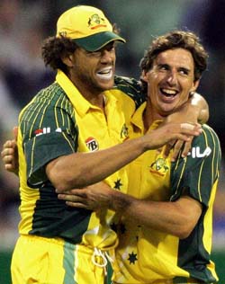 Australia's Bradd Hogg hugs team-mate Andrew Symonds after taking the wicket of West Indies captain Brian Lara in Melbourne