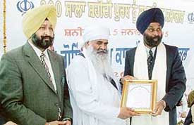 City based film producer Amarjeet Singh being honoured by Baba Maan Singh Ji at for producing films on Sikh history, at SGGS College, Sector 26, Chandigarh on Saturday.