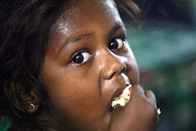 Salomia, a 3-year-old Sri Lankan girl orphaned by the tsunami, eats lunch at a make-shift relief camp in Kalmunai on Saturday