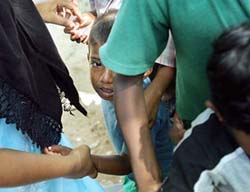 A Sri Lankan boy, displaced due to the tsunami, cries as he is unable to set his share of candy from a 
