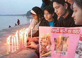 Members of the Servants of the Peoples Society light candles to pay tributes to the tsunami victims, at Sukhna Lake in Chandigarh