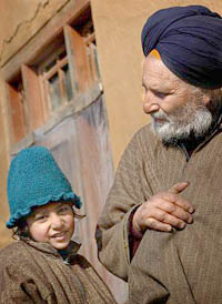 Five-year-old Arandeep Singh, who lost his father Sartaj Singh in the Chattisinghpora village massacre, with his grandfather