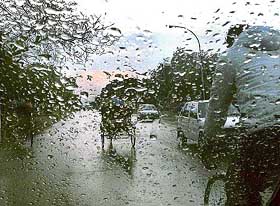 Commuters on their way to office in a slight drizzle in Chandigarh on Monday. 