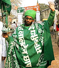 An RJD worker campaigns for his party in front of the state BJP office in Patna on Monday
