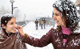 A girl cleans the snow from her friend’s face during a heavy snowfall in Shimla on Monday.