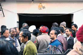 Neighbours gather outside the house of the Passi family in Ludhiana on Monday