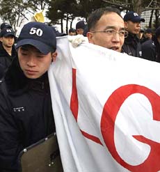 South Korean police block retailers and wholesalers of music records trying to march towards the headquarters of the LG Group at a protest in Seoul on Tuesday. 