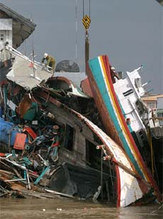 An Australian Army soldier works to remove vessels swept onto a bridge by the tsunami in Banda Aceh on the Indonesian island of Sumatra
