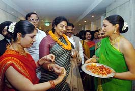 Minister of State for Tourism Renuka Chowdhury (C), is greeted by girls in traditional attire during the unveiling of a campaign, Atithi Devo Bhava, in New Delhi