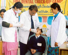 Doctors of Baba Jaswant Singh Dental College and Hospital examine a child at  Springdale Public School in Ludhiana