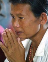 Htu, a 34-year-old Myanmar migrant worker, cries as she prays on Wednesday for her two daughters killed by the Indian Ocean tsunami