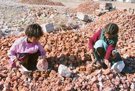 LEARNING THE LESSON OF LIFE THE HARD WAY: Two children, when they should be school, break bricks for a living near a construction site in Ludhiana