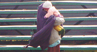  A mother tries to keep her baby warm in the Capital on Friday