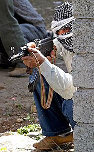 An armed masked insurgent keeps watch for US and Iraqi security forces in the Iraqi city of Mosul 