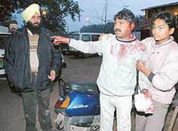 Profusely bleeding Sunil Kumar, the owner of a tavern, points towards one of the assailants in Chandigarh on Saturday. 