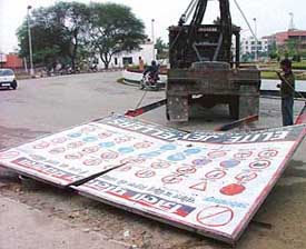 HUDA officials remove boards and hoardings from various sectors in Panchkula on the directions of the Election Commission on Saturday