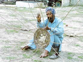 A farmer in a village near Ludhiana weaves a basket