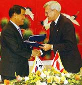 Kim Ssang-Soo, LG Electronics Chief Executive (left), exchanges an agreement with Williams Owens, Nortel Chief Executive from Canada, during signing an MoU to establish a joint venture on telecom equipment and networking solutions, in Seoul