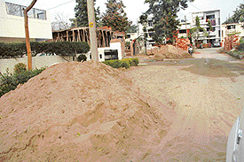 construction material lying in the middle of an intra-sectoral road in Phase IV