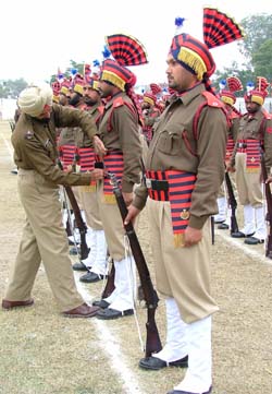 A police officer checks the belt of a colleague during the rehearsal for the Republic Day parade in Ludhiana on Monday