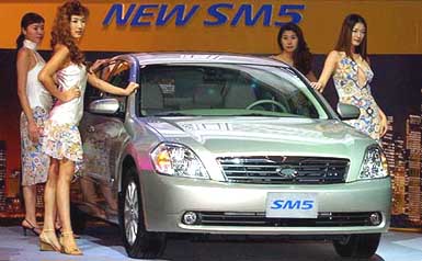 South Korean models pose with a NEW SM5 of the Renault Samsung Motors during a press unveiling in Seoul on Tuesday.