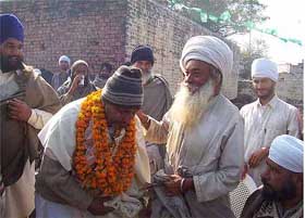 Mr Boota Singh, INLD nominee from Guhla Cheeka in Kaithal district, seeks the blessings of a religious dera chief during campaigning on Thursday