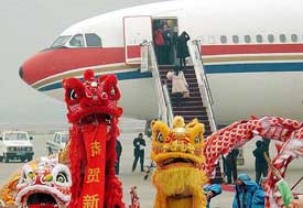 Taiwanese passengers board onto China Eastern jet, the first direct Chinese plane to fly from Shanghai to Taiwan, as lion dancers perform to celebrate at Pudong International Airport in Shanghai