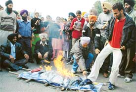 Unemployed teachers burn an effigy of Education Minister Harnam Dass Johar in front of his house in Ludhiana