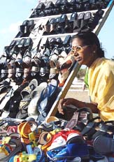 Shoe vendor Mutthulakshmi sits beside her roadside stall in Chennai on Monday. Mutthulakshmi sells a variety of footwear earning about Rs 120 per day.