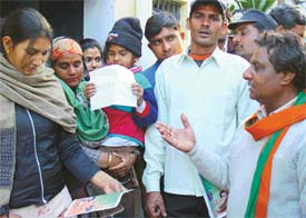 BJP candidate Sham Lal Bansal makes a point with a voter at Majri village,near Panchkula, on Monday