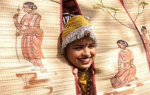 A folk artist from Haryana peeping through a wall mat of Chattisgarh