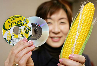 Victor Company of Japan (JVC) employee Fusako Adachi displays 8cm-diameter DVD disks, which are made of vegetable-based plastic at the company's office in Tokyo on Thursday. JVC developed environment-friendly optical disks by using polylactic acid made by corn starch. 