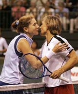 American tennis players Martina Navratilova and Monica Seles exchange kisses