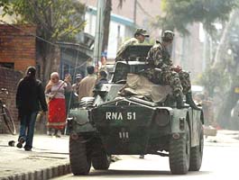 Nepali military personnel sit atop an armoured vehicle as they keep watch on a street in Kathmandu on Friday. 
