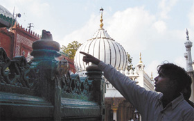 A boy pointing to the damaged section of the tomb