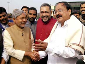 Senior BJP leader Venkaiah Naidu shakes hands with JD(U) leader Nitish Kumar at the Patna airport on Tuesday after announcing that the latter will be made the Chief Minister if the NDA alliance secures a majority in Bihar. 