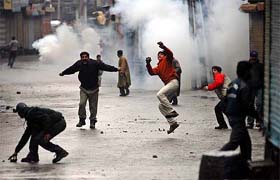 Youths pelt the police with stones in protest against the death of a man at Maisuma in Srinagar