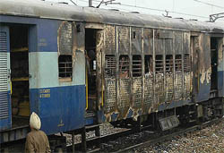 A person inspects a coach of the Nanded-bound Sachkhand Express, which caught fire on the Amritsar-Jalandhar rail section near Hamira, on Wednesday morning. 