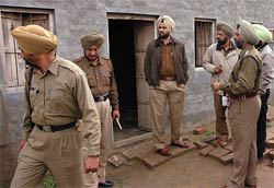 Police officials inspect the site where two migrant labourers were stabbed to death in Mithapur village in Jalandhar district on Wednesday. 