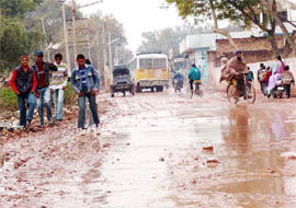 Pedestrians tread the potholed Zira Road in Moga on Wednesday. 